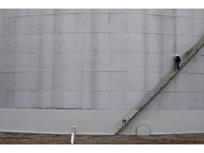 An employee descends a staircase on the side of an oil storage tank during a tour of the Enbridge Inc. Cushing storage terminal in Cushing, Oklahoma, U.S., on Wednesday, March 25, 2015.  Photographer: Daniel Acker/Bloomberg