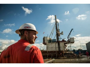A worker, wearing a hardhat featuring a Union Flag, also known as a Union Jack, stands near the drill rig at the Preston New Road pilot gas well site, operated by Cuadrilla Resources Ltd., near Blackpool, U.K., on Tuesday, Sept. 19, 2017. Cuadrilla started drilling the pilot well that is expected to reach depth of 3,500 meters, a core sample will be taken from the well and examined to determine where to drill the horizontal well it intends to frack.