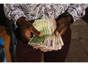 A man holds Zimbabwean dollar bond banknotes for an arranged photograph in Bindura, Zimbabwe on Sunday, July 29, 2018. Zimbabweans will elect a new leader on Monday, eight months after Robert Mugabe's forced resignation, and the contest appears too close to call.