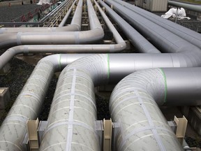 Gas pipes sit near a liquefied natural gas (LNG) storage tank under construction, left, at Tokyo Electric Power Co.'s (Tepco) Futtsu gas-fired thermal power plant in Futtsu, Chiba Prefecture, Japan, on Monday, Sept. 10, 2018. Japan will maintain a target for clean energy to account for as much as 24 percent of the countrys power mix by 2030, according to a long-term plan approved by the Cabinet in July. Photographer: Tomohiro Ohsumi/Bloomberg via Getty Images