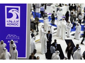 Delegates pass the Abu Dhabi National Oil Co. (ADNOC) display during the Abu Dhabi International Petroleum Exhibition & Conference (ADIPEC) in Abu Dhabi, United Arab Emirates, on Tuesday, Nov. 13, 2018. OPEC's secretary-general, energy ministers from Saudi Arabia to Russia, CEOs at oil majors from Total SA, BP Plc and Eni SpA, and officials from Middle Eastern energy giants such as Abu Dhabi's Adnoc have gathered to sign deals and discuss oil, gas, refining and petrochemical issues. Photographer: Christopher Pike/Bloomberg