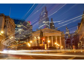 Vehicles leave light trials as they pass the Bank of England (BOE), left, and the Royal Exchange at night in the City of London, U.K., on Tuesday, Aug. 4, 2020. Bank of England officials could signal on Thursday that the case for more monetary stimulus is growing as a nascent rebound from the pandemic-induced recession risks fading.