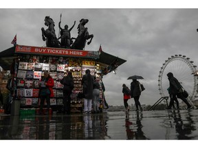 Pedestrians walk past a tourist souvenir stall on Westminster Bridge in London, U.K., on Thursday, Aug. 27, 2020. Mayor of London Sadiq Khan warned that businesses are facing a "perfect storm" from the virus as a result of "home working, the shutdown in domestic and international tourism, and a public transport system with severely constrained capacity."