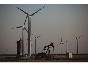 A pump jack stands next to wind turbines near Guymon, Oklahoma, U.S., on Friday, Sept. 25, 2020.