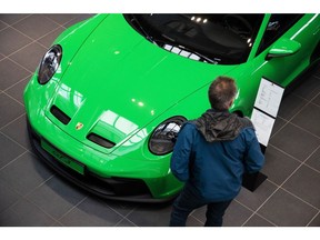 A customer looks at a Porsche GT3 luxury automobile in the Porsche SE showroom in Berlin, Germany, on Tuesday, March 29, 2022. Porsche, which reports reports final year earnings today, delivered 301,915 vehicles to customers in 2021, an 11% jump from 2020 and the first time it has surpassed the 300,000 mark.
