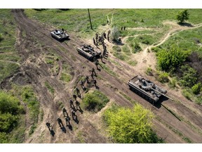 In this aerial view, Ukrainian infantrymen take part in a training exercise with tanks on May 09, 2022 near Dnipropetrovsk Oblast, Ukraine. Infantry soldiers learned scenarios to survive when potentially confronted with a Russian tank closing in at close range. The frontline with Russian troops lies only 70km to the south in Kherson Oblast, most of which is controlled by Russia.