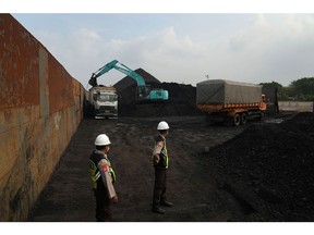 An excavator loads coal at Cirebon Port in West Java, Indonesia. Photographer: Dimas Ardian/Bloomberg
