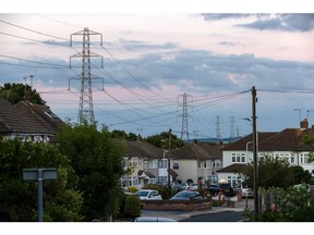 Electricity transmission towers near residential houses in Upminster, UK, on Monday, July 4, 2022. The UK is set to water down one of its key climate change policies as it battles soaring energy prices that have contributed to a cost-of-living crisis for millions of consumers.