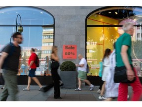 Shoppers pass a 'sale' sign outside a KaDeWe luxury department store in Berlin, Germany, on Tuesday, Aug. 9. 2022. German Finance Minister Christian Lindner said he will look at ways of exempting the country's looming gas levy from sales tax in an effort to at least partially ease the burden on consumers from soaring energy costs. Photographer: Krisztian Bocsi/Bloomberg