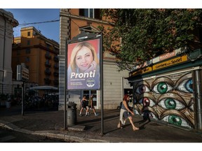 An election poster featuring an image of Giorgia Meloni, leader of the Brothers of Italy party, reading "Ready To Revive Italy", in a residential suburb of Rome, Italy, on Wednesday, Aug. 10, 2022. Italy will hold an early election on Sept. 25. Photographer: Alessia Pierdomenico/Bloomberg