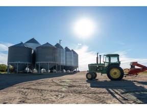A tractor parked parked beside grain silos at a farm near Dinsmore, Saskatchewan, Canada, on Monday, Aug. 29, 2022. Output from the world's seventh-largest wheat exporter will rise 55% to 34.6 million metric tons this year as yields improve amid better moisture and more moderate temperatures, Statistics Canada said Monday in a report.