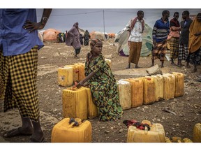 BAIDOA, SOMALIA - SEPTEMBER 3: A girl sits on water bottles in a displacement camp for people impacted by drought on September 3, 2022 in Baidoa, Somalia. Extreme drought has destroyed crops and seen a hike in food prices, leaving 7 million people (out of a total population of 16 million) at risk of famine in Somalia.