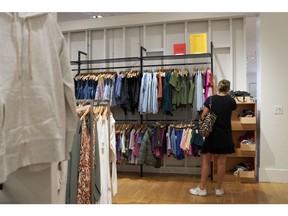 LOS ANGELES, CA - SEPTEMBER 20: A woman shops the sale section at a Gap retail store on September 20, 2022 in Los Angeles, California. Gap Inc. is set to cut about 500 corporate jobs as the clothing retailer faces cutbacks due to declining sales, as well as Kanye West ending Yeezy's partnership with Gap Inc.