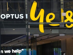 FILE - An Optus phone sign hangs above its store in Sydney, Australia, Thursday, Oct. 7, 2021. Australia's federal and state governments on Wednesday, Sept. 28, 2022, called for Optus to pay for replacing identification documents including passports and driver's licenses to avoid identity fraud after 9.8 million of the telecommunications company's customers had personal data stolen by computer hackers.