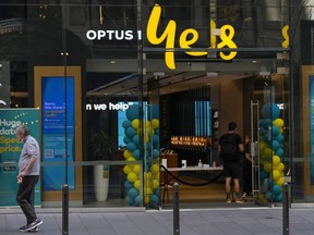 FILE - A customer waits for service at a Optus phone store in Sydney, Australia, Thursday, Oct. 7, 2021. The Australian government said on Monday, Sept. 26, 2022, it was considering tougher cybersecurity rules for telecommunications companies after Optus, the nation's second-largest wireless carrier, reported personal data of 9.8 million customers had been breached.