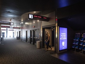 A moviegoer steps out of an auditorium at a Cineplex movie theatre in Toronto on Friday, July 16, 2021.