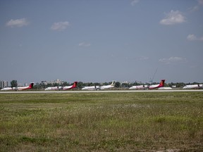 A row of De Havilland Dash-8 airplanes sit outside the Downsview plant in Toronto on Tuesday, August 24, 2021. Alberta Premier Jason Kenney says a new airplane manufacturing plant is to be built near Calgary.