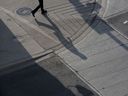 Der Schatten eines Pendlers wirft sich auf den Bürgersteig im Finanzviertel von Toronto.