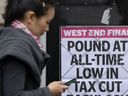 Eine Frau geht an einer Schlagzeile vorbei, die an einer Wand in London angebracht ist.  Die Bank of England und die britische Regierung versuchen, die Märkte zu beruhigen, die wegen einer volatilen britischen Wirtschaft und Währung nervös sind.