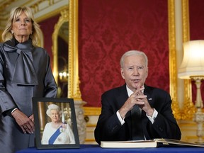 President Joe Biden speaks after signing a book of condolence at Lancaster House in London, following the death of Queen Elizabeth II, Sunday, Sept. 18, 2022, as first lady Jill Biden looks on.