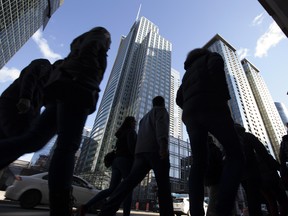 Pedestrians walk in front of office buildings in Montreal.