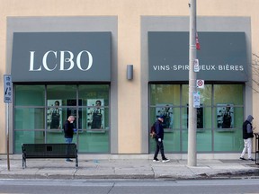 People wait outside of the LCBO to purchase alcohol in Toronto.
