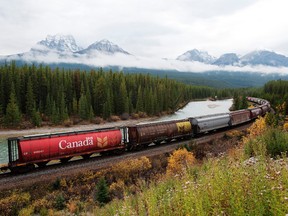 Rail cars loaded with Canadian wheat travel through the Rocky Mountains on the Canadian Pacific Railway line near Banff, Alta.