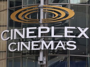 A Cineplex movie theatre sign looms over Yonge street in Toronto.