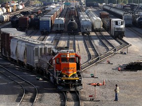FILE- A BNSF rail terminal worker monitors the departure of a freight train, on June 15, 2021, in Galesburg, Ill. The major freight railroads say in a new report Thursday, Sept. 8, 2022, designed to put pressure on unions and Congress, that a strike would cost the economy more than $2 billion a day and disrupt deliveries of all kinds of goods and passenger traffic nationwide if it happens after a key deadline passes next week without a contract agreement.
