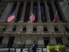 FILE - A trader looks over his cell phone outside the New York Stock Exchange, Wednesday, Sept. 14, 2022, in the financial district of Manhattan in New York.