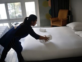 FILE - In this Thursday, Sept. 20, 2018 photo, a cleaning lady works in an apartment located on Airbnb in Paris. Airbnb hosts are facing an onslaught of frustrations born of renting out their properties to short-term guests. Certain guests have proven disrespectful of hosts' homes, with some squatting illegally -- and getting away with it -- and others trashing properties with Silly String, feces and more.