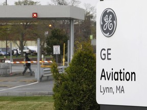 In this April 19 2011 file photo the General Electric logo is seen on a sign at the entrance to the aviation manufacturing plant in Lynn, Mass. The largest union representing workers for General Electric Co. says it's reached an agreement with the company to speed up raises for workers at the Massachusetts aviation plant. Under the deal, workers would be eligible for raises sooner and could reach the top pay rate after six years of work, instead of as many as 10 required under the old system. The tentative agreement first reported Tuesday, Sept. 13, 2022 must be ratified by workers in a vote set for later this month.