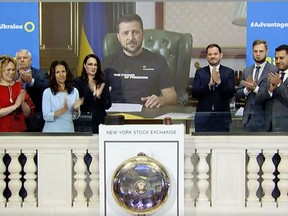 In this still photo taken from video provided by the New York Stock Exchange, Ukraine's President Volodymyr Zelenskyy, center, virtually rings the opening bell at the NYSE, Tuesday, Sept. 6, 2022, to mark the launch of the Advantage Ukraine Initiative. (New York Stock Exchange via AP)