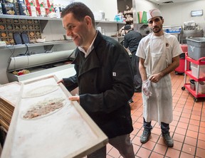 Mohamad Fakih, left, works with a Syrian refugee at one of his restaurants in Mississauga, Ontario, in 2016.