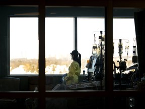 A registered nurse takes a moment to look outside while caring for a ventilated COVID-19 patient in the intensive care unit at Humber River Hospital during the COVID-19 pandemic in Toronto on January 25 2022. Canada is facing a wave of retirements by workers in high-pressure sectors, with more retiring before their 65th birthday.