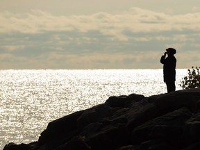 A person is silhouetted as they look out over Lake Ontario in Mississauga, Ont., on Monday, October 31, 2016. When it comes to uncomfortable conversations, matters of inheritance may be near the top of the list. But as the cost of living rises and the generational wage gap grows wider, experts say it is now more important than ever to open up that dialogue.