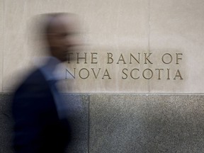 A commuter walks past the Bank of Nova Scotia in Toronto's financial district.