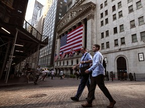 Morning commuters walk past the New York Stock Exchange on Sept. 9.