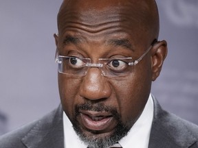 FILE - Sen. Raphael Warnock, D-Ga., speaks to reporters at the Capitol on July 26, 2022 in Washington.  Georgia voters will see at least one fall debate between Sen. Raphael Warnock and Republican challenger Herschel Walker.  Warnock accepted Walker's motion for the October 14 debate in Savannah on Tuesday evening.