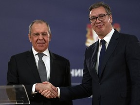 FILE - Russian Foreign Minister Sergey Lavrov, left, shakes hands with Serbia's President Aleksandar Vucic after a press conference in Belgrade, Serbia, Sunday, Oct. 10, 2021. European Union candidate Serbia has signed an agreement with Russia to hold mutual "consultations" on foreign policy matters. Serbian Foreign Affairs Minister Nikola Selakovic signed the agreement with Russian Foreign Minister Sergey Lavrov on the margins of the U.N. General Assembly.