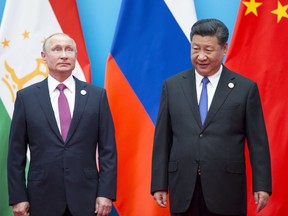 FILE - Chinese President Xi Jinping, right, and Russian President Vladimir Putin pose for a photo at the Shanghai Cooperation Organization (SCO) Summit in Qingdao in eastern China's Shandong Province on June 10, 2018. President Xi Jinping is using his first trip abroad since the start of the pandemic to promote China's strategic ambitions at a summit with Putin and other leaders of a Central Asian security group.