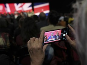 A woman takes pictures as Keir Starmer, the leader of Britain's Labour Party makes his speech at the party's annual conference in Liverpool, England, Tuesday, Sept. 27, 2022.