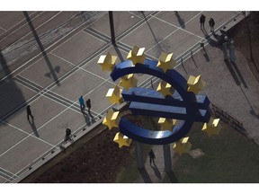 Pedestrians pass the Euro symbol sculpture, as seen from the Commerzbank AG headquarters during a news conference to announce the bank's fourth-quarter earnings in Frankfurt, Germany, on Thursday, Feb. 9, 2017. Commerzbank reported a 5.2 percent decline in fourth-quarter profit as it set more money aside for troubled loans to the shipping industry and low interest rates continued to weigh on income from lending. Photographer: Krisztian Bocsi/Bloomberg