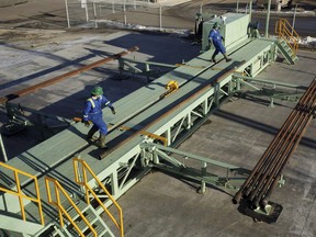 Trainees roll pipe off the catwalk during a training session to lay down drill pipe on a rig floor at Precision Drilling in Nisku, Alta., on January 20, 2016.
