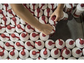 A worker collects bottles of Moutai baijiu from a cart at the Kweichow Moutai Co. factory. in Maotai town in Renhuai, Guizhou province, China, Thursday, Dec. 14, 2017. Moutai baijiu's taste and potential price appreciation are driving demand for blisters. That in turn has pushed its market value to more than $145 billion, more than British giant Diageo Plc. Photographer: Qilai Shen/Bloomberg