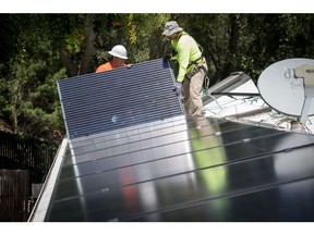 PetersenDean Inc. employees install solar panels on a home in Lafayette, California, U.S., on Tuesday, May 15, 2018. California became the first state in the U.S. to require solar panels on almost all new homes. Most new units built after Jan. 1, 2020, will be required to include solar systems as part of the standards adopted by the California Energy Commission. Photographer: David Paul Morris/Bloomberg