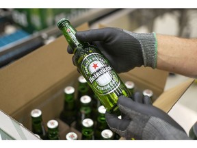 An employee carries out quality checks on a Heineken beer bottle on a packaging conveyor at the Heineken NV brewery in Zoeterwoude, Netherlands, on Wednesday, May 30, 2018. Heineken has acquired Stellenbrau, a beer maker based in South Africa's western Cape, submitted a bid for a local Coca-Cola bottler and built a brewery in Ivory Coast to take on market leader Castel.