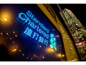 Signage is illuminated at a Standard Chartered Plc bank branch at night in Hong Kong, China, on Thursday, July 25, 2019. Standard Chartered is scheduled to release interim earnings results on Aug. 1. Photographer: Paul Yeung/Bloomberg