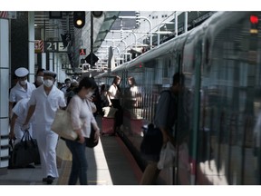Passengers embark an East Japan Railway Co. (JR East) Shinkansen bullet train at Tokyo Station in Tokyo, Japan, on Aug. 7, 2020. Mid-August is a traditional time for many Japanese to leave the densely populated cities and travel to meet family in rural areas. But reservations of bullet trains over this year's Obon period are at just 16% of last year's, according to JR East.
