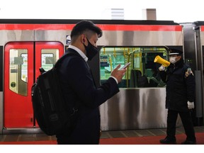 A commuter walks past a Hokuso-Railway Co. train at the platform of Chiba Newtown Chuo station in Inzai, Chiba Prefecture, Japan, on Monday, March 8, 2020. Japanese Prime Minister Yoshihide Suga extended by two weeks a virus state of emergency for the Tokyo region that has expired on Sunday, trying to maintain a declining trend in infections as the country looks to host the Olympics in about four months.